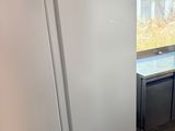 a white refrigerator in a kitchen with a sink and a window