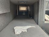 a bed in the back of a truck with a blanket on it