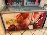 a display case with ice cream and strawberries on it
