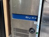 several stainless steel refrigerators are stacked on a shelf in a store