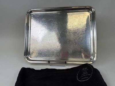 un plateau en argent recouvert d'un tissu noir posé sur la table