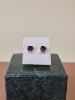 boucles d'oreilles en améthorate posées sur un bloc de marbre