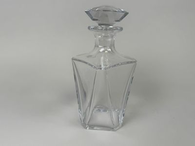 clear glass bottle with a diamond shaped top on a white surface