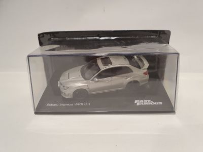 a white toy car in a clear box on a table