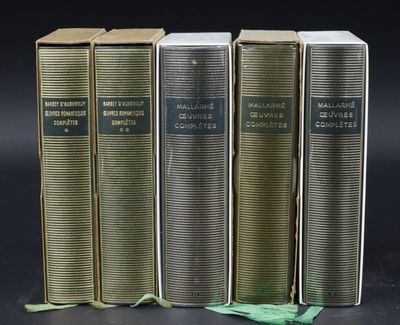 three old books are lined up on a black surface