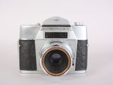 a silver camera with a brown lens on a white surface