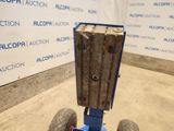 a blue cart with a piece of wood on top of it