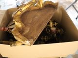 une boîte en carton remplie de bouteilles de vin et d'une statue en or