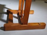 a wooden table with a wooden base on a white floor
