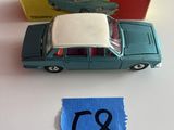 une petite voiture miniature recouverte d'un tissu bleu posée sur la table