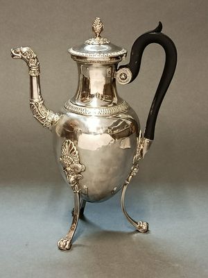 une théière ancienne en argent, munie d'une anse et d'un pied