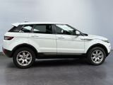 the white range rover is parked in a room with a gray wall