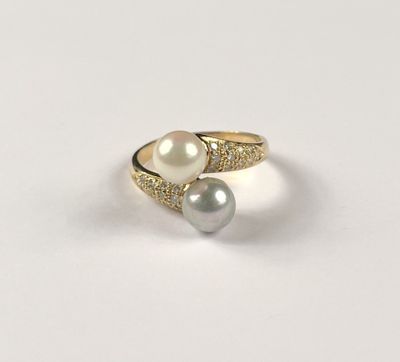 a close up of a ring with two pearls on it