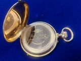 a gold pocket watch sitting on a blue surface