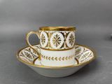 a close up of a cup and saucer on a table