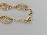 a close up of a gold bracelet on a white surface