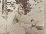an old photo of a woman making something out of clay