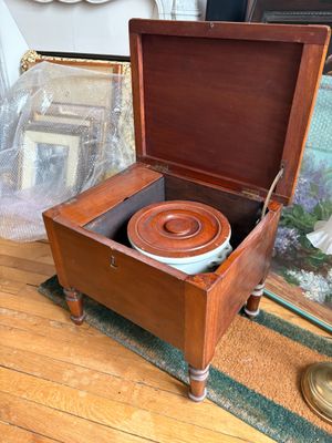 une boîte en bois munie d'un couvercle, à l'intérieur de laquelle se trouve un bol