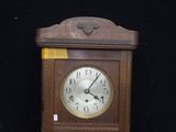 a wooden clock that is sitting on a black surface