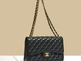 a black chanel bag with a gold chain strap