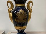 a blue and gold vase sitting on top of a table