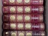une boîte remplie de livres rouges ornés de dorures