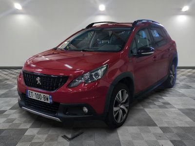 la voiture rouge est garée sur un sol en damier dans le garage