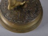a bronze statue of a bird sitting on top of a box