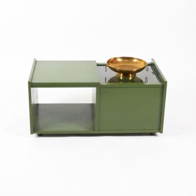 a green coffee table with a bowl on top of it