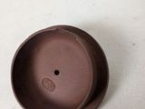 a small brown cup sitting on a white surface