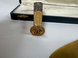 a gold lighter sitting on a white table next to a book