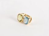 un gros plan d'une bague en or sertie de deux pierres de couleurs différentes