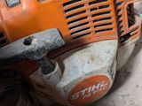 an orange chainsaw sitting on top of a table next to other tools