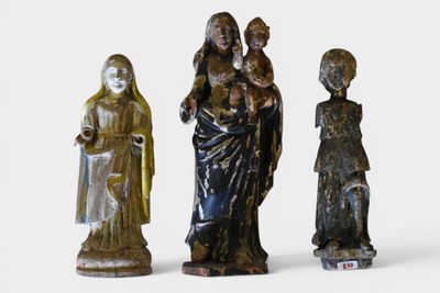 three figurines of a woman holding a child and a man holding a child