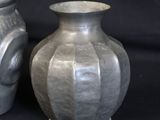 two vases sitting next to each other on a black background