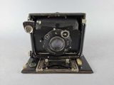 an old black camera sitting on top of a white surface