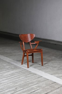une chaise en bois qui se trouve au milieu d'une pièce