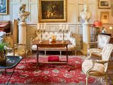 un salon avec beaucoup de meubles et des tableaux accrochés aux murs