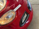 a close up of a red car with a sticker on it