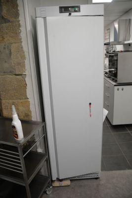 a white refrigerator sitting in a kitchen next to a table