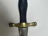 a close up of a sword on a white surface