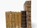 plusieurs vieux livres sont empilés sur une surface blanche