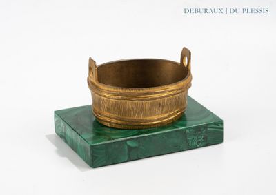 a green marble base with a brass bowl on it