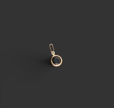 une boucle d'oreille plaquée or avec une pierre noire au centre