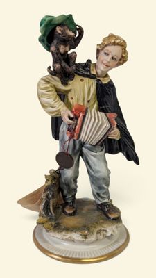 une figurine représentant un garçon et un chien sur un socle