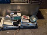 many containers of food sitting on the floor next to a sink