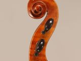 an antique violin with a scroll and a bow on a stand