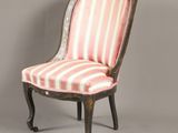 une chaise ancienne dont le dossier et les pieds sont recouverts d'un tissu rayé