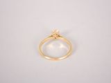 a close up of a gold ring on a white surface