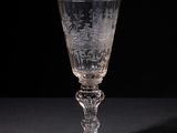 a wine glass sitting on a table with a black background